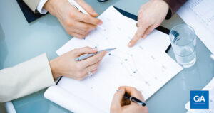 mãos de executivos sobre papel com gráficos - senso de importância da imprensa