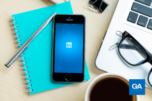mesa com objetos de trabalho e celular conectado ao LinkedIn